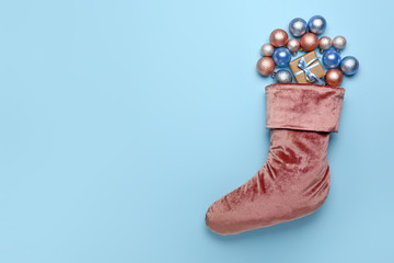 Christmas sock with gift on color background