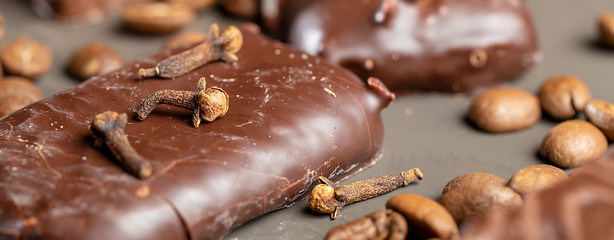 Appetizing food background. Sweets, candies, coffee beans and spices close-up on dark backdrop. Panoramic banner.