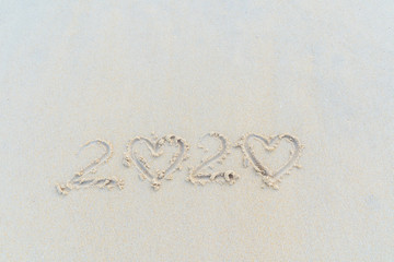 Concept Happy New Year 2020 on the beach Tropical design made in Phuket, Thailand Write the alphabet on the sand background Taken from real locations.