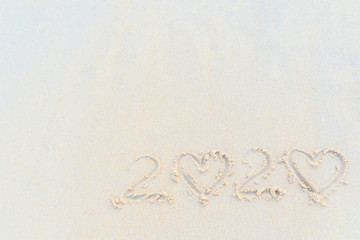 Concept Happy New Year 2020 on the beach Tropical design made in Phuket, Thailand Write the alphabet on the sand background Taken from real locations.