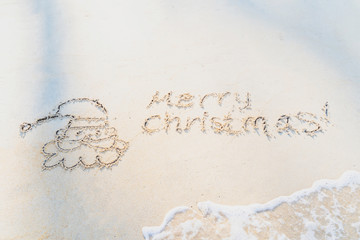 Concept Christmas on the beach Tropical design made in Phuket, Thailand Write the alphabet on the sand background Taken from real locations.