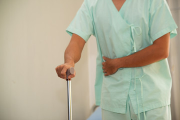 The male patient had a stomach ache and walked into the room using a walking stick as an anchor....