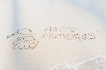Concept Christmas on the beach Tropical design made in Phuket, Thailand Write the alphabet on the sand background Taken from real locations.