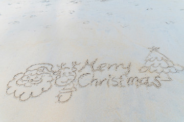 Concept Christmas on the beach Tropical design made in Phuket, Thailand Write the alphabet on the sand background Taken from real locations.