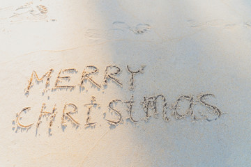 Concept Christmas on the beach Tropical design made in Phuket, Thailand Write the alphabet on the sand background Taken from real locations.