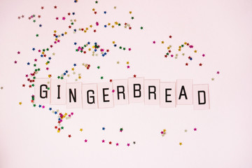 The inscription gingerbread on a pink background with glitters