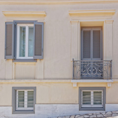 light ocher colored house front with grey windows, Athens Greece, Plaka neighborhood
