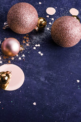 Christmas background. Christmas golden toy, glitter balls on dark blue background. Copy space Minimalism, flat lay