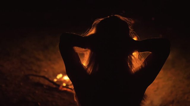 Silhouette of mystic woman in black background of fire fly flame, spark, of contour outline. Adult sexy of young girl witchcraft ceremony ritual dance in underclothes. Outdoor slow motion. Caucasian.
