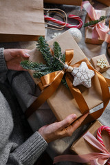 Woman holds a Christmas present in hands. Happy holiday, gift box close-up. Surprise for Boxing day, Christmas and New Year party. Magic time. Celebration winter event. Wrapping paper, toys and ribbon