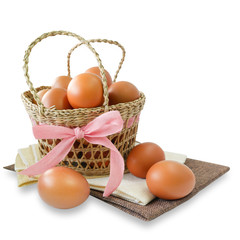 Healthy food, Isolated fresh brown chicken eggs in basket decorated with pink ribbon on white background (with clipping path)