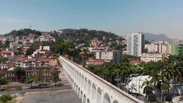 Epic drone video of the tram, bonde do lapa, on the famous touristic arcos of lapa and paning away on the cityscape of santa teresa in rio de Janeiro brazil.