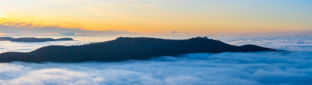 Germany, XXL panorama of aerial view above endless fog clouds in valley of swabian jura nature landscape at sunset near stuttgart on mountain breitenstein with view to castle teck