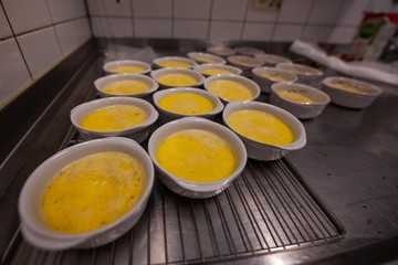 bowls of unfinished creme brulee in commercial kitchen