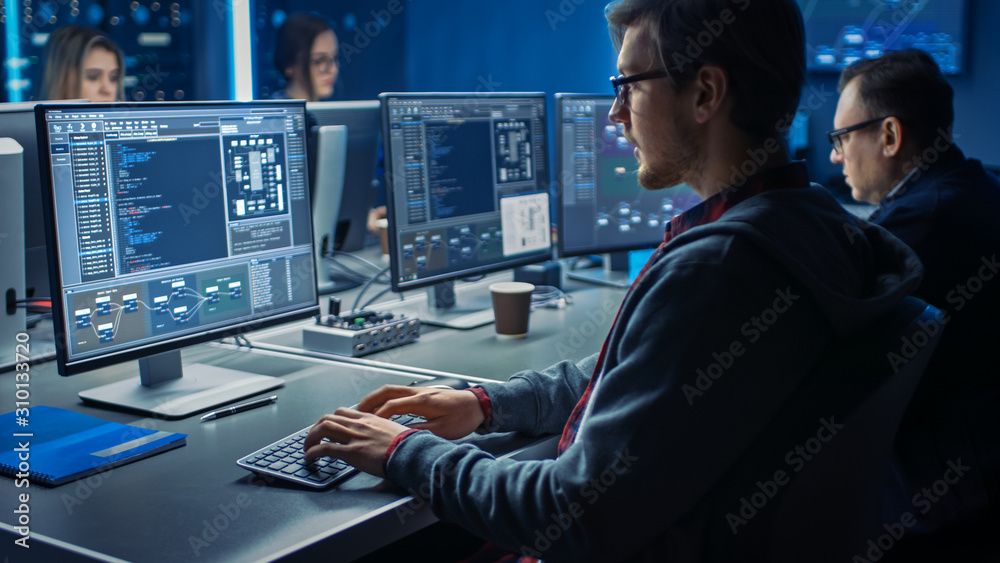 Fototapete Smart Male IT Programer Working on Desktop Green Mock-up Screen Computer in Data Center System Control Room. Team of Young Professionals Programming Sophisticated Code