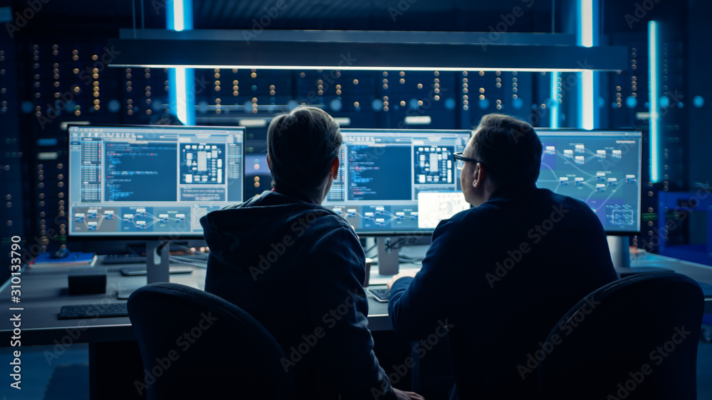 Fototapete Two Professional IT Programers Discussing Blockchain Data Network Architecture Design and Development Shown on Desktop Computer Display. Working Data Center Technical Department with Server Racks 