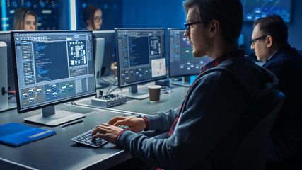 Smart Male IT Programer Working on Desktop Green Mock-up Screen Computer in Data Center System...