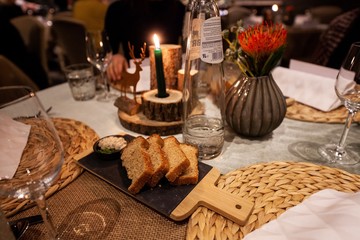 sliced toasted hard crust bread on wooden platter on table in fancy restaurant