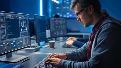 Software Developer Programming, Finding Solutions while Working on Desktop Computers in Data Center System Control Room. Team of Young Professionals Doing High Tech Coding 