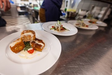 fancy fried tofu being plated in commercial kitchen
