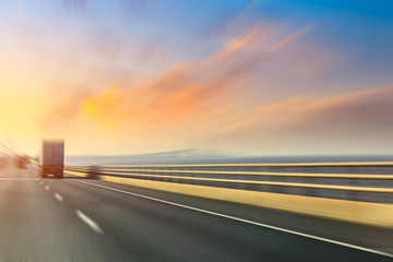 Blurred motion of truck and asphalt road at dusk