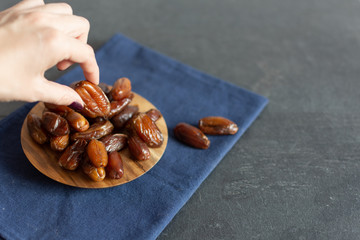 Bowl of dried dates on wooden background with space for text.