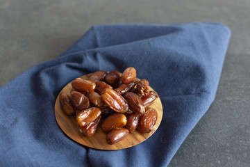 Bowl of dried dates on wooden background with space for text.