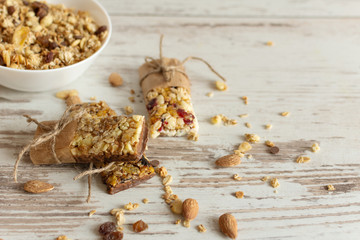 Cereal granola bar with nuts, fruit and berries on wooden table background. Healthy sweet dessert snack.