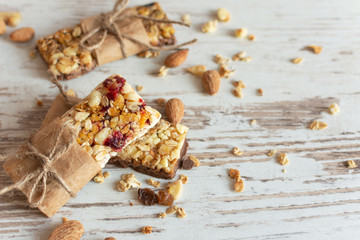 Cereal granola bar with nuts, fruit and berries on wooden table background. Healthy sweet dessert snack.