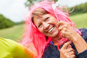Fröhliche Senior Frau mit rosa Perücke