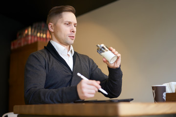 Man with sugar bowl in his hands sitting at table