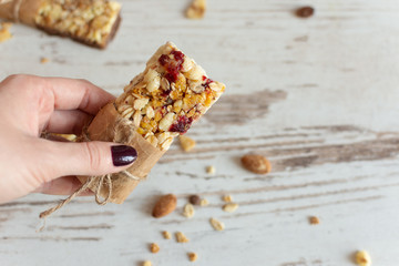 Cereal granola bar with nuts, fruit and berries on wooden table background. Healthy sweet dessert...