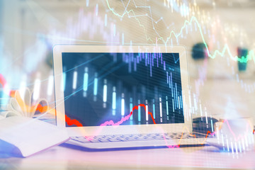 Forex graph hologram on table with computer background. Multi exposure. Concept of financial markets.