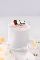 Lassi milkshake on a white plate next to ice. Fermented drink