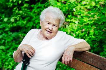 Portrait of old granny on a park bench nice
