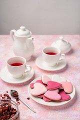 Fototapeta na wymiar Heart shape cookies with icing with berry tea. Concept: Valentine's Day tea party, festive table setting in pink.