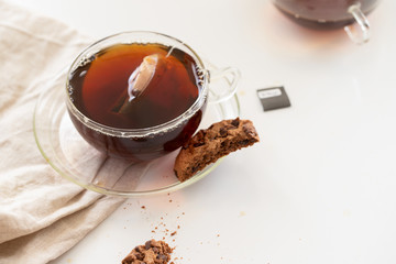 Glass of black tea with cookies on white background. Hot drink concept.