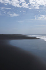 Obraz na płótnie Canvas black lava sand beach on a tropical island