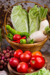 fresh mixed organic vegetables in bamboo basket on old wood table background
