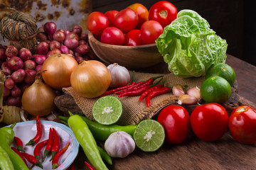 fresh mixed organic vegetables in bamboo basket on old wood table background