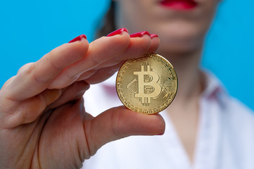 Young unidentified woman holding a bitcoin coin