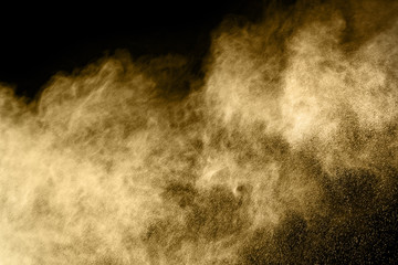 Golden powder explosion on black background.