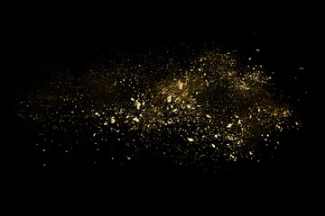 Golden powder explosion on black background.