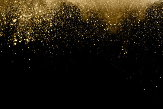 Golden powder explosion on black background.