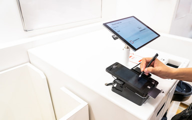 customer signing the signature for paying bill. customer uses a credit card to pay for goods by the machine automatically in the shop, new normal payment concept.