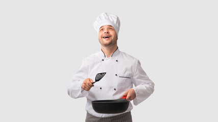 Cook Man Holding Pan And Spatula Looking Up, White Background