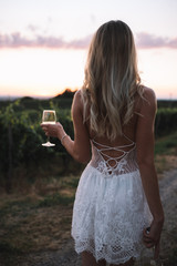 Portrait of a gorgeous blonde woman in white dress having fun in vineyards  in summer day. Female...