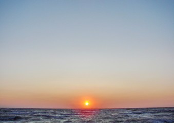 Obraz premium Incredible natural picture of a colorful sky over the stormy blue infinity of the Azov Sea at dawn.