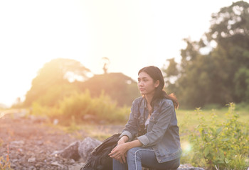 Beautiful Asian girl wearing a jeans shirt. She are using binoculars to look for places that are for travel the holidays.