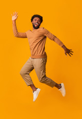Fototapeta na wymiar Funny laughing afro guy jumping in the air